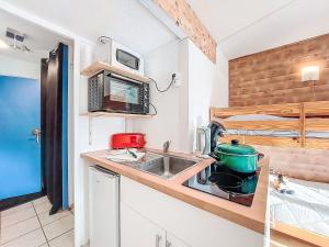 a kitchen with a sink and a microwave at Apartment Soyouz Vanguard-106 by Interhome in Le Corbier