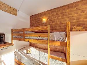 two bunk beds in a room with wooden walls at Apartment Soyouz Vanguard-106 by Interhome in Le Corbier