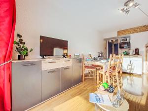 a living room with a kitchen with a tv and a table at Apartment Soyouz Vanguard-106 by Interhome in Le Corbier
