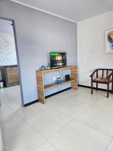 a living room with a tv on a white wall at Casa 264 in Capão da Canoa