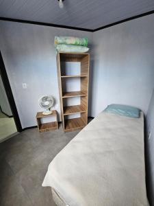 a small bedroom with a bed and a shelf at Casa 264 in Capão da Canoa