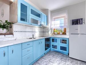 a kitchen with blue cabinets and a white refrigerator at Villa Elli by Interhome in Tinjan