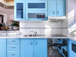 a kitchen with blue cabinets and a sink at Villa Elli by Interhome in Tinjan