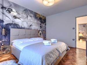 a bedroom with a large bed with a painting on the wall at Villa Elli by Interhome in Tinjan