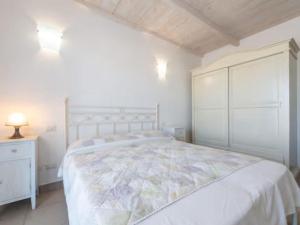 Apartment Casa Elena by Interhome في فيلاسيميوس: غرفة نوم بيضاء مع سرير كبير مع اللوح الأمامي كبير