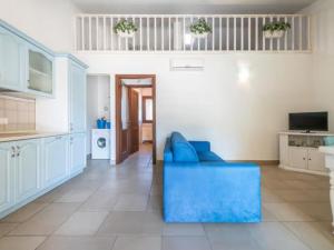 Apartment Casa Elena by Interhome في فيلاسيميوس: غرفة معيشة مع أريكة زرقاء ومطبخ