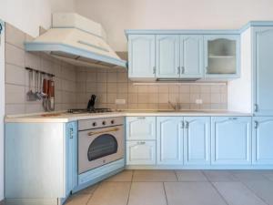 Apartment Casa Elena by Interhome في فيلاسيميوس: مطبخ مع دواليب زرقاء وموقد