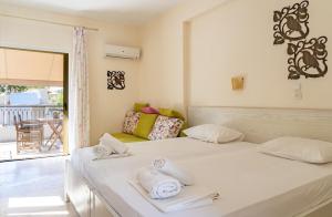 a bedroom with a bed with towels on it at Villa Nefeli Skiathos in Skiathos Town
