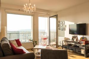 ein Wohnzimmer mit einem Sofa und einem großen Fenster in der Unterkunft Sky View Apartment Vienna in Wien