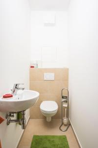 ein Badezimmer mit einem weißen Waschbecken und einem WC in der Unterkunft Sky View Apartment Vienna in Wien