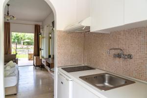 a kitchen with a sink and a tile wall at Villa Nefeli Skiathos in Skiathos Town +43 photos