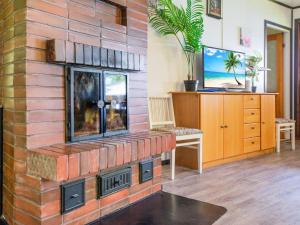 un camino in mattoni in un soggiorno con TV di Holiday Home D daalia by Interhome a Kalmari