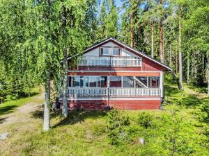 una casa rossa con balcone nel bosco di Holiday Home D daalia by Interhome a Kalmari