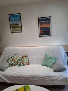 a white couch in a living room with two pictures on the wall at Le studio d' EMI in Argelès-Gazost