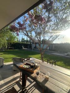 マイプにあるEl Atelierの木の木のパティオに並ぶ木製テーブル