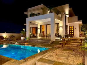 a villa with a swimming pool at night at Fleur&Sel Westcoast Villa in Flic-en-Flac