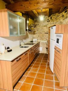 a kitchen with wooden cabinets and a white refrigerator at Casa Solle - Bonita casa de montaña a 20 min de San Isidro 