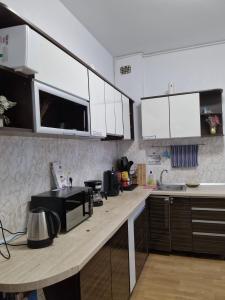 a kitchen with white cabinets and a wooden counter top at Hostel Andrei in Iaşi