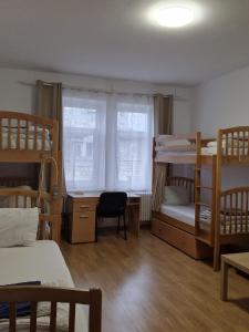 a dorm room with bunk beds and a desk and a window at Hostel Andrei in Iaşi
