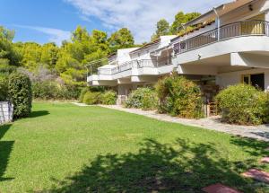 a building with a lawn in front of it at Villa Nefeli Skiathos in Skiathos Town
