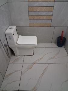 une salle de bain avec des toilettes blanches dans une chambre dans l'établissement Jerusalem Home Saty, à Idukki