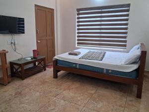 un petit lit dans une chambre avec une fenêtre dans l'établissement Jerusalem Home Saty, à Idukki