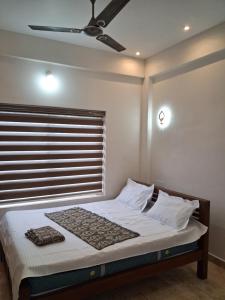une chambre avec un lit avec un ventilateur de plafond dans l'établissement Jerusalem Home Saty, à Idukki 10 autres photos