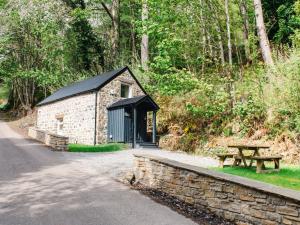 un pequeño edificio con un banco y una mesa en Holiday Home Wayside Bothy by Interhome, en Drumnadrochit