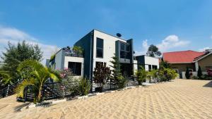 a house with plants in front of a fence at AGASARO LUXURY Apartment in Kigali
