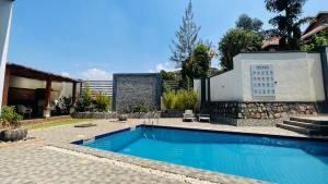 a swimming pool in front of a house at AGASARO LUXURY Apartment in Kigali