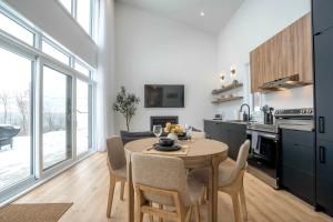 a kitchen and dining room with a table and chairs at Modern Comfort - Spa - Mountain - Chalet KNOX in Saint Come