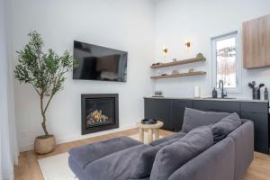 a living room with a couch and a fireplace at Modern Comfort - Spa - Mountain - Chalet KNOX in Saint Come