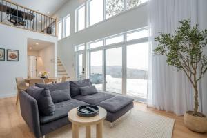 a living room with a gray couch and a tree at Modern Comfort - Spa - Mountain - Chalet KNOX in Saint Come +15 photos