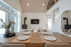 a dining room with a wooden table with wine glasses at Modern Comfort - Spa - Mountain - Chalet ALBA in Saint Come