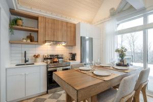 a kitchen with a wooden table with chairs and a kitchen with a stove at Modern Comfort - Spa - Mountain - Chalet ALBA in Saint Come