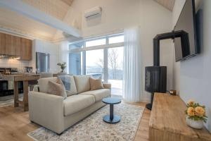 a living room with a white couch and a table at Modern Comfort - Spa - Mountain - Chalet ALBA in Saint Come