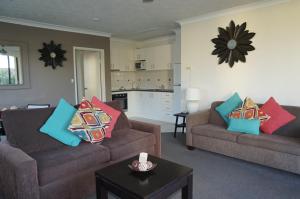 a living room with two couches and a kitchen at Aussie Resort in Gold Coast