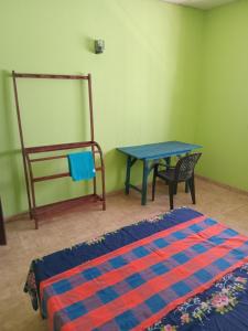 um quarto com uma cama, uma mesa e uma cadeira em Amaya Hostel and Restaurant em Batigama