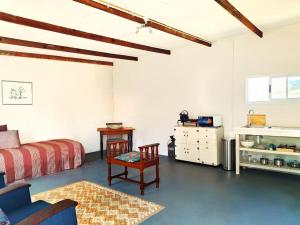 a bedroom with a bed and a table and a chair at Cornelia's Field in Joubertina