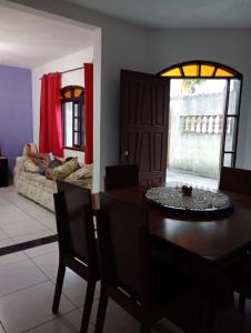 een woonkamer met een tafel en een bank bij Casa Pé na Areia in Mongaguá