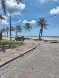 een lege weg naast een strand met palmbomen bij Casa Pé na Areia in Mongaguá