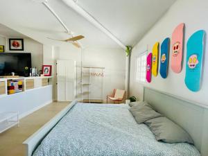 1 dormitorio con cama y tablas de surf en la pared en The happy garage at the beach, en La Cala de Mijas 20 fotos más