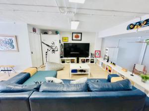 Una sala de estar con un sofá azul y un televisor de pantalla plana. en The happy garage at the beach, en La Cala de Mijas