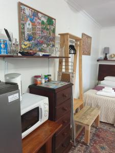a kitchen with a microwave on a dresser and a bed at Hibiscus B&B in Strand