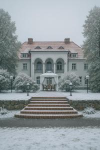 a building with a table and a tent in the snow at Rezydencja Willa Park & Restauracja in Legnica