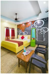 a bedroom with a bed and a painting on the wall at Hotel JK Seaside Inn Near Jagannath Temple - Fully Air Conditioning Deluxe Room - Free Wifie and Parking - Rooftop Sea View Hotel In Puri in Puri +9 photos