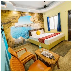 a hotel room with a bed and a table at Hotel JK Seaside Inn Near Jagannath Temple - Fully Air Conditioning Deluxe Room - Free Wifie and Parking - Rooftop Sea View Hotel In Puri in Puri