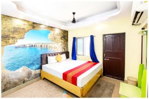 a bedroom with a bed and a painting of the ocean at Hotel JK Seaside Inn Near Jagannath Temple - Fully Air Conditioning Deluxe Room - Free Wifie and Parking - Rooftop Sea View Hotel In Puri in Puri