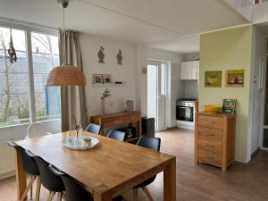 a kitchen and dining room with a table and chairs at Villa Noordenwind in Julianadorp