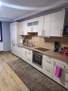Una cocina con gabinetes blancos y un fregadero. en Monteurwohnung Ferienwohnung, en Velbert